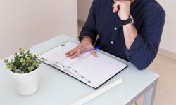 crop-man-reading-notes-notebook_23-2147785057